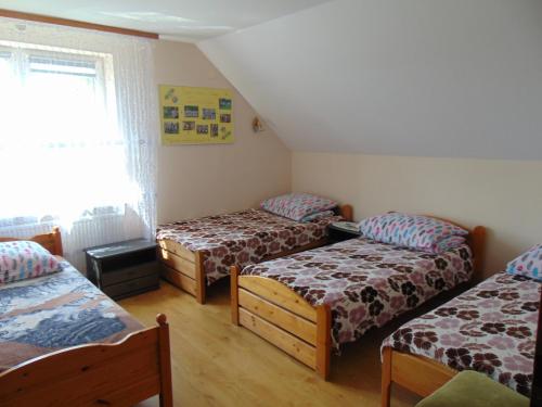 a room with three beds and a window at Gospodarstwo Agroturystyczne Lucynka in Urszulin