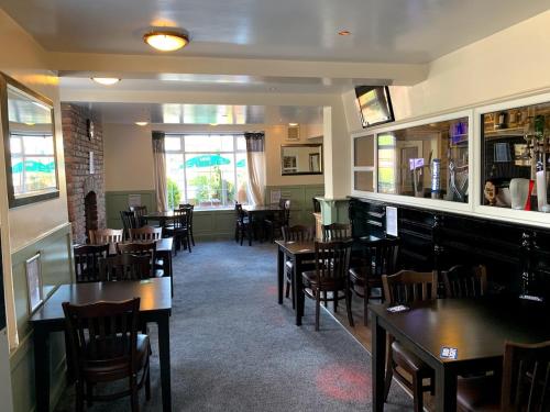 uma sala de jantar com mesas e cadeiras num restaurante em White Horse Tavern em Telford