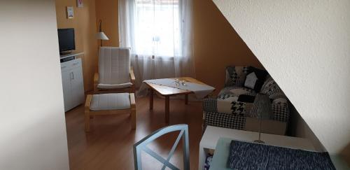 a small living room with a table and a chair at Sebol in Immendingen