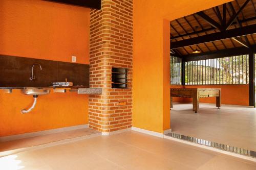 a bathroom with orange walls and a sink and a table at Estâncias da Serra dos Alves in Itabira