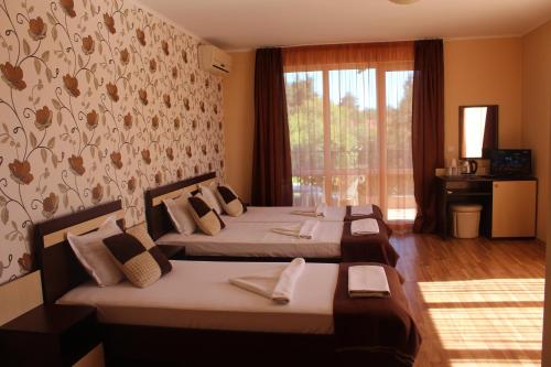 a bedroom with two beds and a window at Respekt Guest House in Sunny Beach