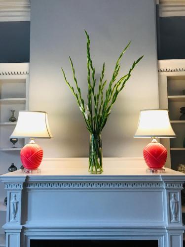 two lamps on a mantle with a vase of flowers at West End Inn in Portland