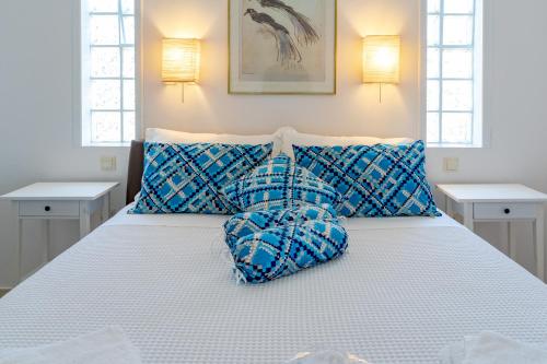a bedroom with a bed with blue pillows at Yoga Euphoria seaside apartment in Artemida