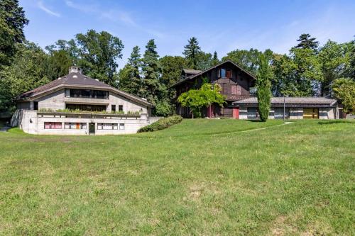 ein großes Haus auf einem Hügel mit einem Grasfeld in der Unterkunft John Knox International Center in Genf