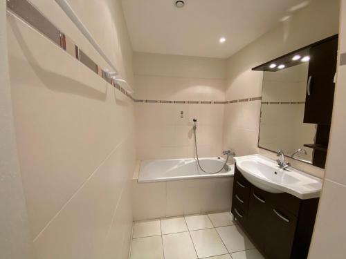 ein weißes Badezimmer mit einer Badewanne und einem Waschbecken in der Unterkunft Mini villa résidence Solenzara Favone in Sari Solenzara