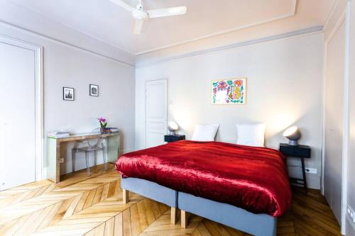une chambre avec un lit avec une couverture rouge dans l'établissement Greeter-Bel appartement Parisien de 70m2 - St Lazare, à Paris