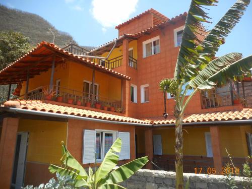 an orange house with a palm tree in front of it at Pousada do Ceu in Paul