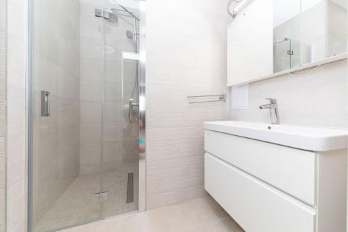 a white bathroom with a shower and a sink at Villa Olivia Trogir in Trogir