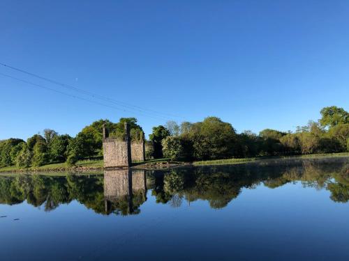 uma ponte velha sobre a água de um rio em Ardhowen Bay lakefront holiday accommodation em Enniskillen