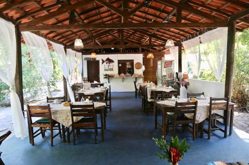 um restaurante com mesas e cadeiras num pavilhão em Villa da Barca na Ilha de Boipeba