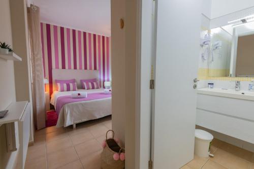um quarto com uma cama e uma parede rosa em Casa da Praia em Zambujeira do Mar