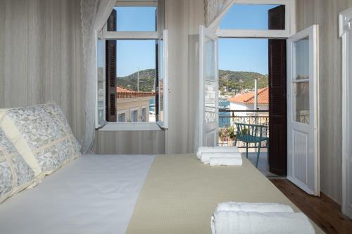 a bedroom with a large bed with two windows at Neoclassical manor house in Poros