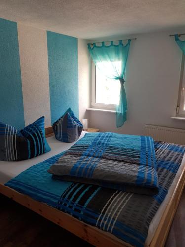 a bedroom with a bed with blue sheets and a window at Ferienwohnung Willkommen in Bad Schandau
