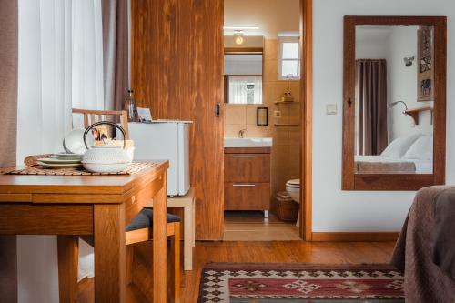 Zimmer mit einem Tisch und einem Bad mit einem Spiegel in der Unterkunft Casa do Valle in Sintra