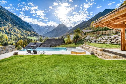 a backyard with a pool and mountains in the background at Penthouse im Chalet GM by A-Appartments in Gallaverda