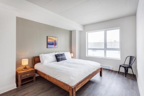 a bedroom with a large bed and a window at L'Equinox Modern Apartments by Corporate Stays in Laval