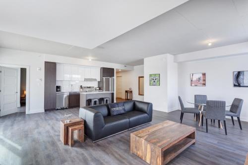 a living room with a couch and a table at L'Equinox Modern Apartments by Corporate Stays in Laval