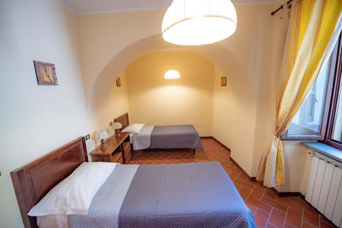 a bedroom with a bed and a desk and a window at Abadia Farneto in Gubbio