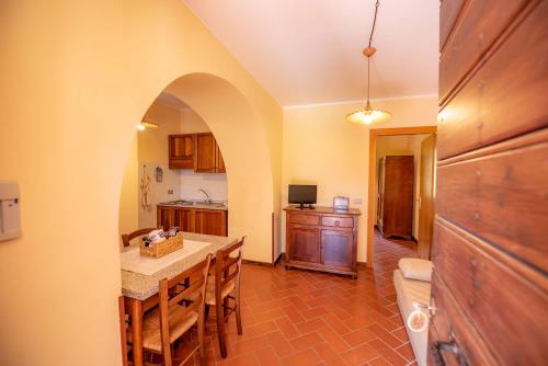 a kitchen with a table with chairs and a counter top at Abadia Farneto in Gubbio