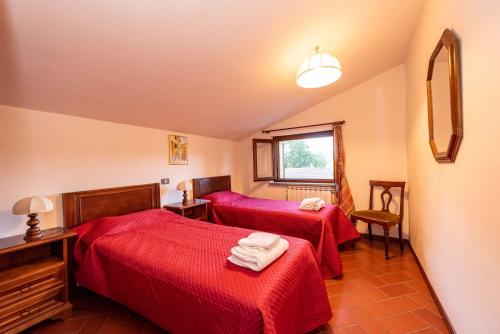 a hotel room with two beds and a window at Abadia Farneto in Gubbio