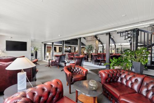 a living room with leather couches and chairs at Ski Lodge Gautefall in Gautefall
