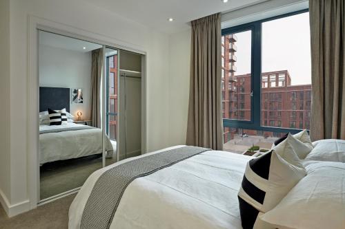 a bedroom with two beds and a large window at Manchester Media City by Charles Hope in Manchester