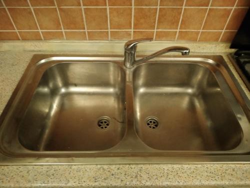 a stainless steel sink with a faucet in a kitchen at trivanio semplice in Sassari