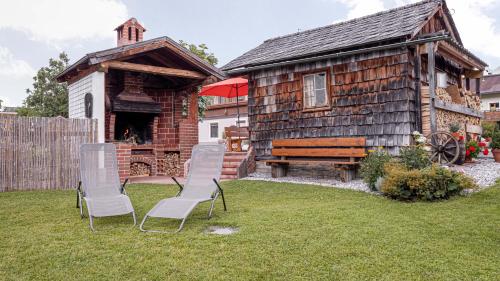 two chairs and a bench in front of a cabin at Haus Regina in Strobl
