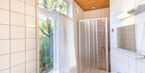 een badkamer met een douche, een wastafel en een raam bij Hanko Villa Anke & Janne in Hanko