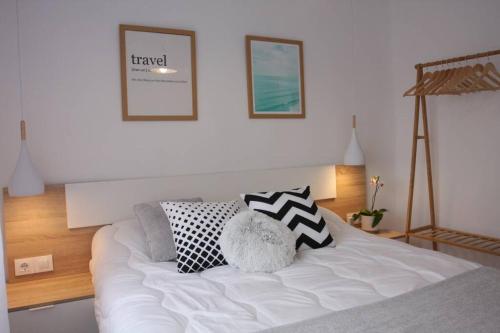 a bedroom with a white bed with pillows on it at Apartamentos La Herradura Balcón in Haro