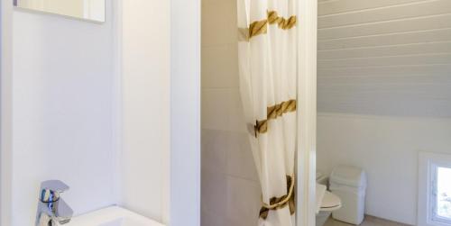 a bathroom with a shower curtain with gold bows at Hanko Villa Anke & Janne in Hanko