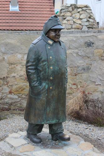 a statue of a man in a coat and hat at Bungalow Putim in Písek