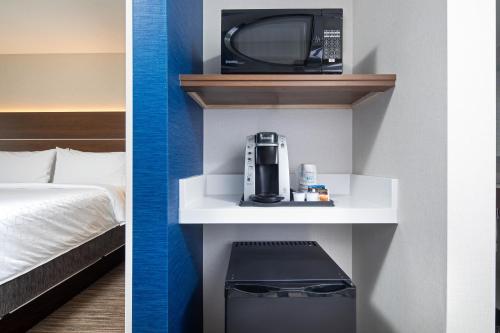 two photos of a hotel room with a bed and a microwave at Holiday Inn Express & Suites Halifax Airport by IHG in Enfield