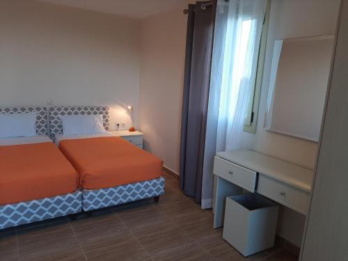 a bedroom with a bed and a desk and a window at Astra Villas in Skala Kefalonias