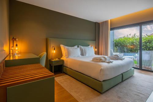 een slaapkamer met een groot bed en een raam bij Quinta do Pedregal Hotel & Spa in Vila Nova de Gaia