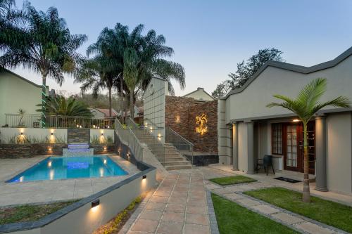 a backyard with a swimming pool and a house at The Cycad Lodge & Chalets in Nelspruit