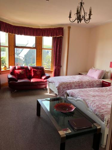 a hotel room with two beds and a coffee table at Rockvilla Guest House in Lerwick