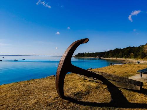 a statue of a long horn sitting on a bench near the water at Hotel La Voilerie Cancale bord de mer in Cancale