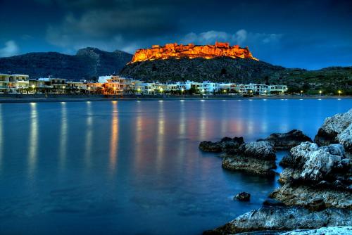 a castle on top of a hill over a body of water at Villa Haraki Paradise in Haraki