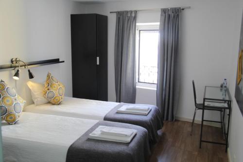 a hotel room with two beds and a window at StayInn City - Évora in Évora