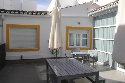 a patio with a table and an umbrella at StayInn City - Évora in Évora