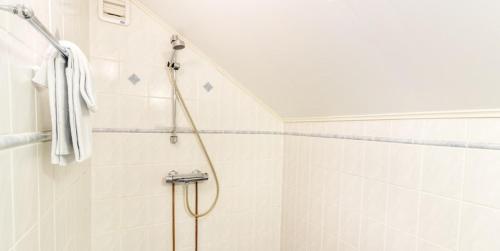 a bathroom with a shower with a white tiled wall at Hanko Villa Anke & Janne in Hanko