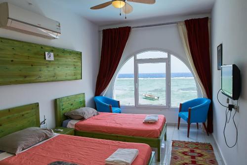 a room with two beds and a window with the ocean at Solaris in Dahab