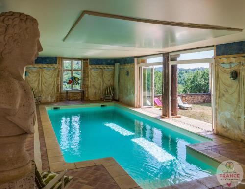 - une piscine dans une maison avec une grande fenêtre dans l'établissement gite des rois ducs, à Sauveterre-la-Lémance
