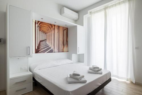 - une chambre blanche avec un lit et une grande fenêtre dans l'établissement Studio II a pochi passi dalla cineteca by Wonderful Italy, à Bologne