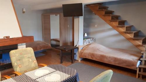 ザコパネにあるNoclegi Zakopaneの階段、ベッド、テーブルが備わる客室です。