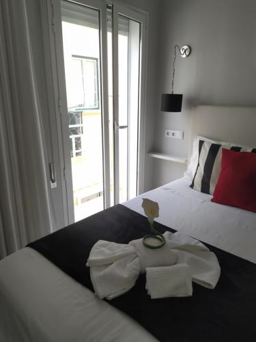 ナザレにあるFerhouseDreams-Praiaのベッドルーム1室(ベッド1台、タオル2枚付)