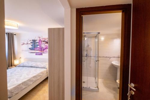 um quarto com uma cama e uma cabina de duche em vidro em La casa di Lally em Fiano Romano