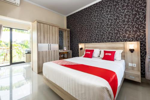 ein Schlafzimmer mit einem großen Bett mit roten Kissen in der Unterkunft OYO 3779 North Wing Canggu Resort in Canggu