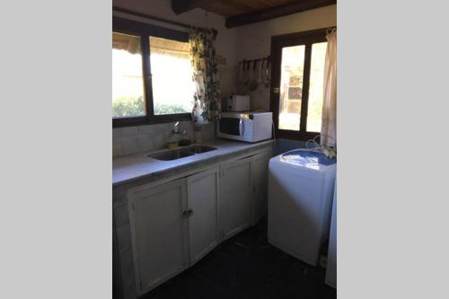 a small kitchen with a sink and a microwave at LO DE MARILITA in La Floresta